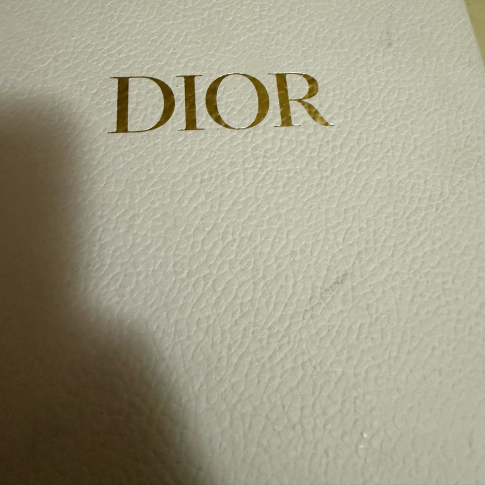 Dior Gold on Textured White Surface